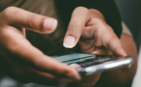 A person types on their mobile phone	